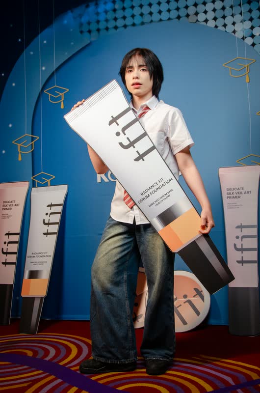 Creador posando con una réplica gigante del producto frente al muro de tfit