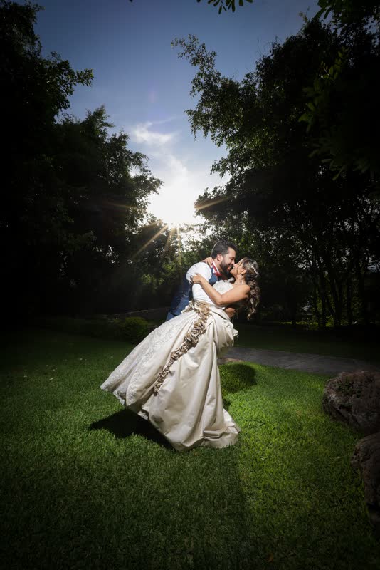 Pareja bailando en un jardín a contraluz