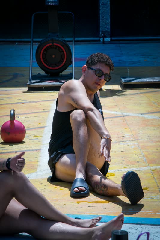 Atleta sentado en la azotea con una kettlebell roja al lado