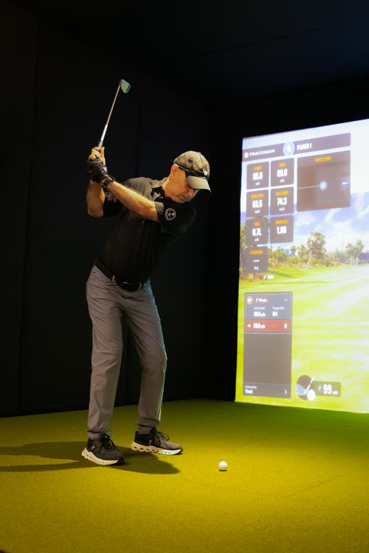 Golfista en pleno swing frente al simulador