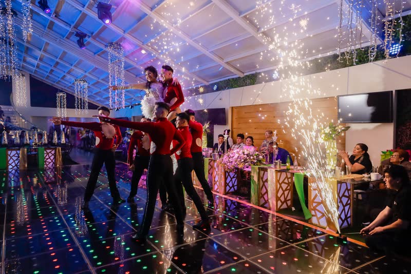 Bailarines de rojo en la pista iluminada durante la fiesta de XV